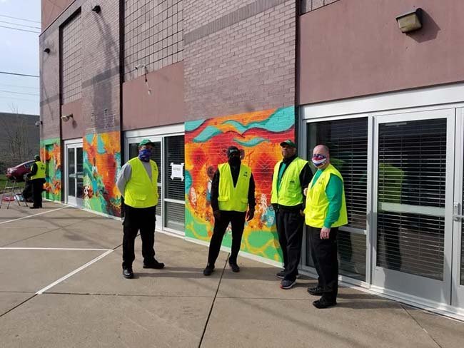 MAD DADS volunteers in safety vests staffing a neighborhood distribution site