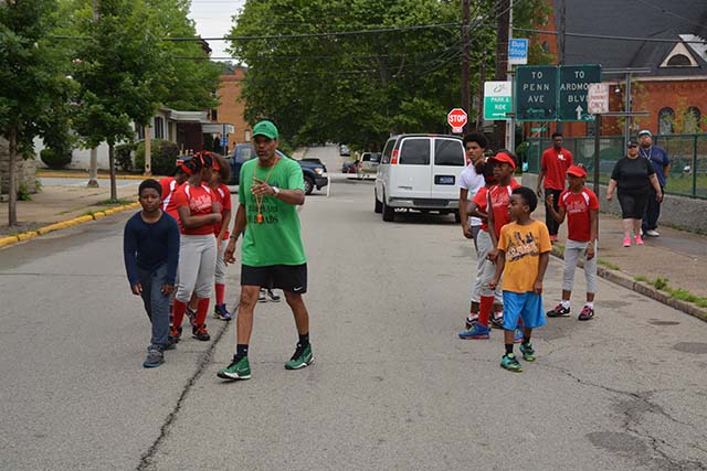 A MAD DADS mentor walking a group of young athletes through their neighborhood